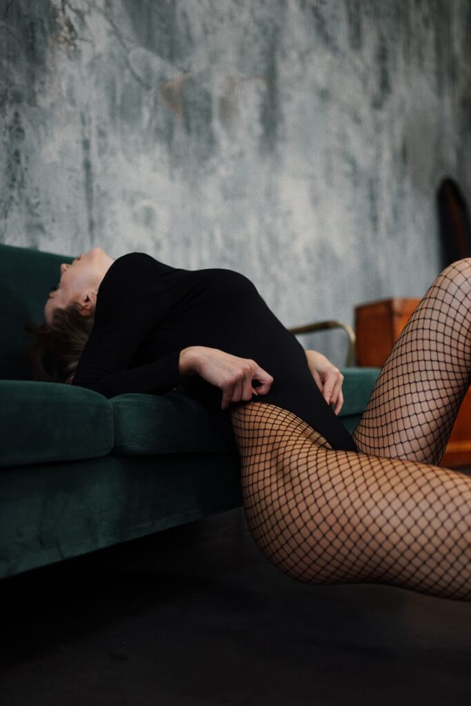 a woman in fishnet stockings laying on a couch
